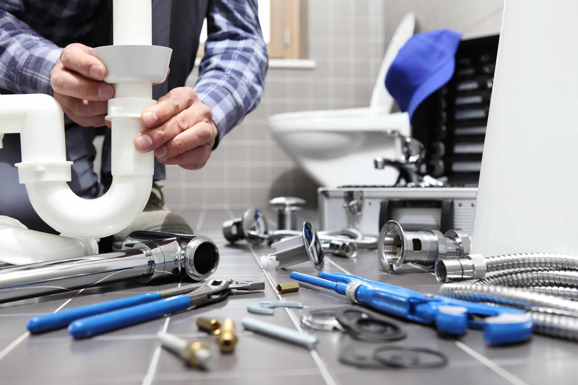 plumber at work in a bathroom plumber at work in a bathroom